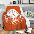 Orange basketball blanket draped over a gray sofa in a cozy living room