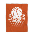 Flat lay of an orange basketball blanket with large white basketball and hoop design