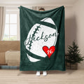 Green football throw blanket with distressed white football artwork and red heart detail
