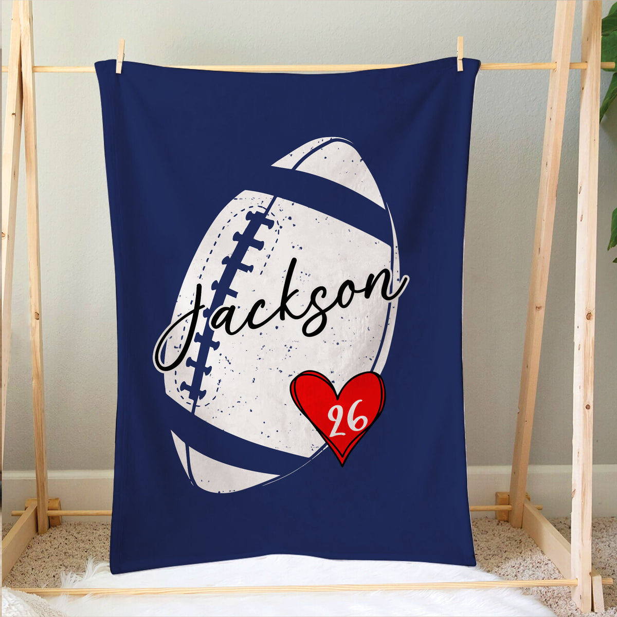 Blue football blanket hanging over a bed with large graphic football artwork