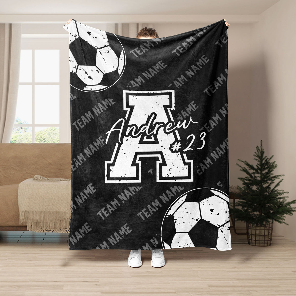 Black soccer blanket featuring white soccer balls, bold athletic graphics, and a monochrome team design