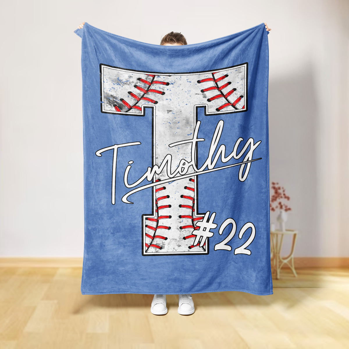 Light blue baseball throw blanket displaying a large stitched baseball design in red, white, and black
