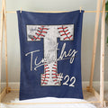 Navy baseball blanket hanging as bedroom decor with a large stitched baseball design