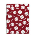 Close detail view of a red softball blanket with repeating white balls and bold sports design