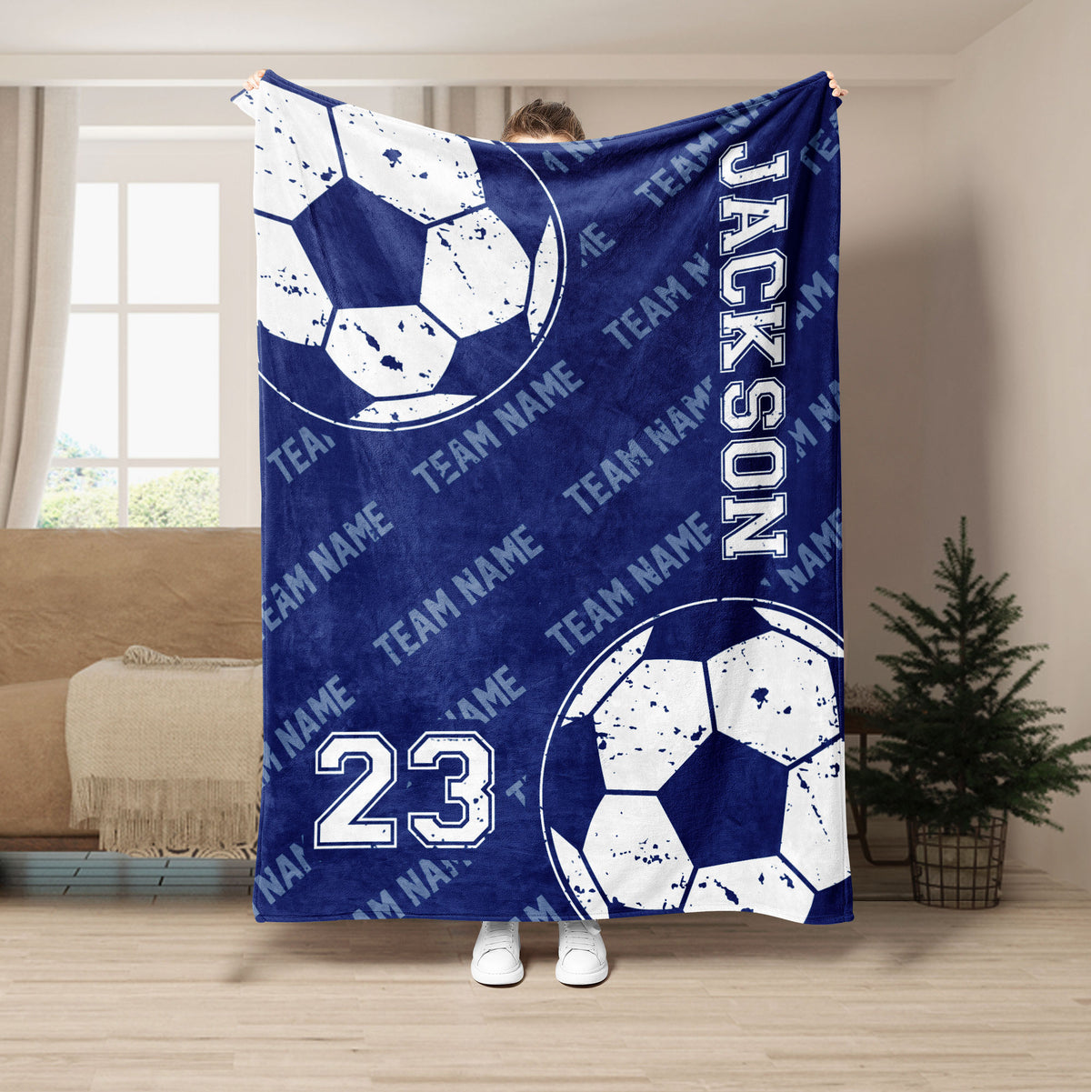 Navy soccer throw blanket displayed in a living room with distressed soccer balls and team-style artwork