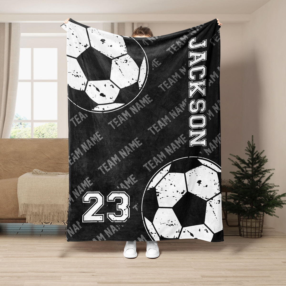 Black soccer throw blanket featuring distressed soccer balls and bold monochrome team sports artwork