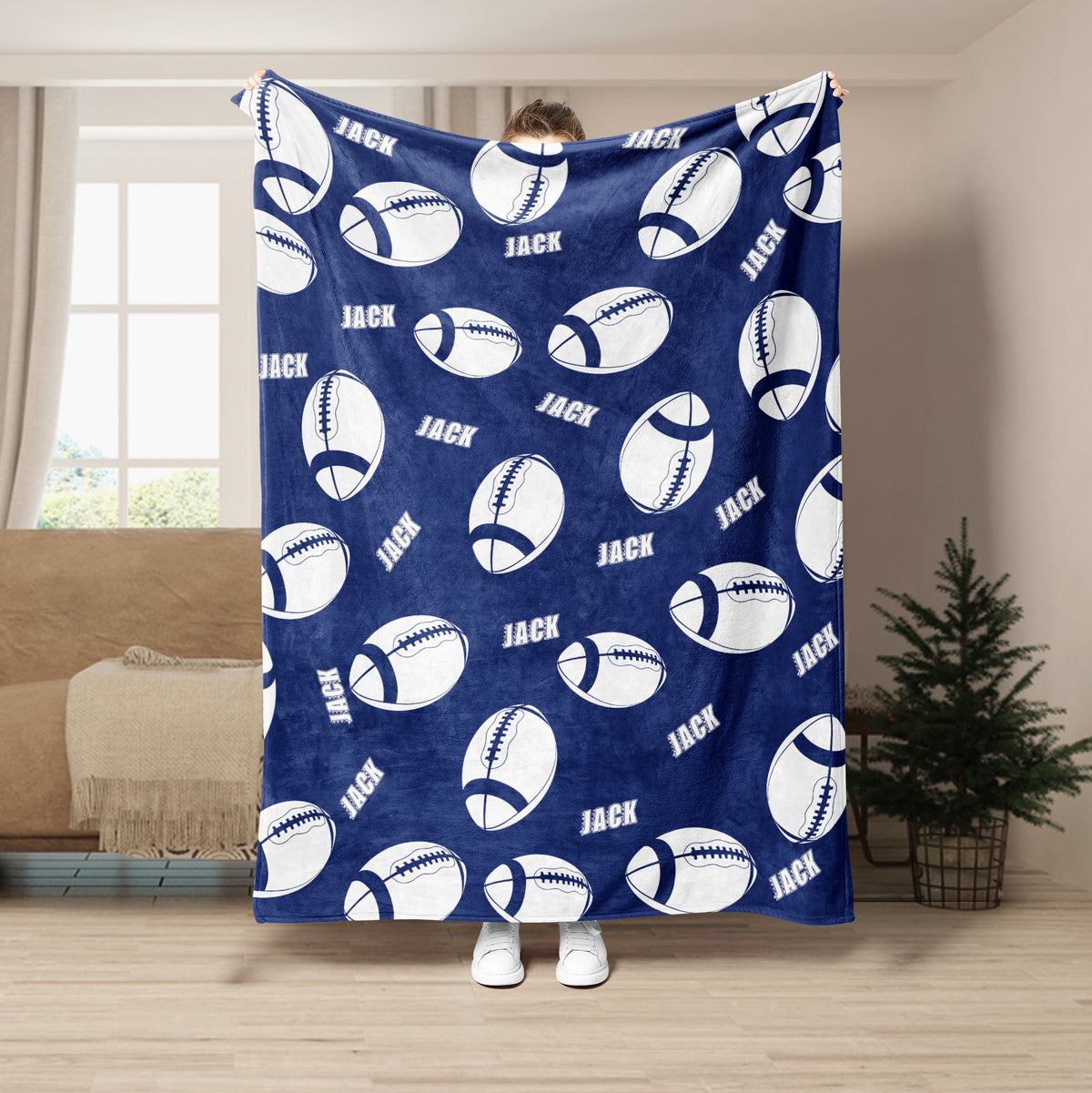 Navy football blanket displayed with repeating white football illustrations in a living room setting