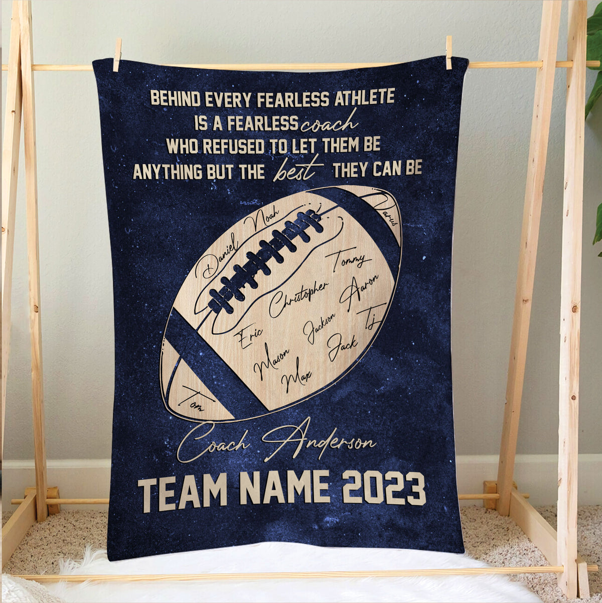 Football coach blanket displayed on a wooden frame with team-inspired artwork