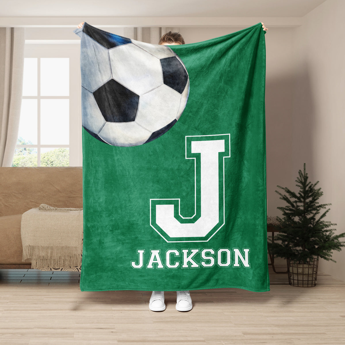 Green soccer throw blanket featuring an oversized soccer ball and bold white athletic letter design