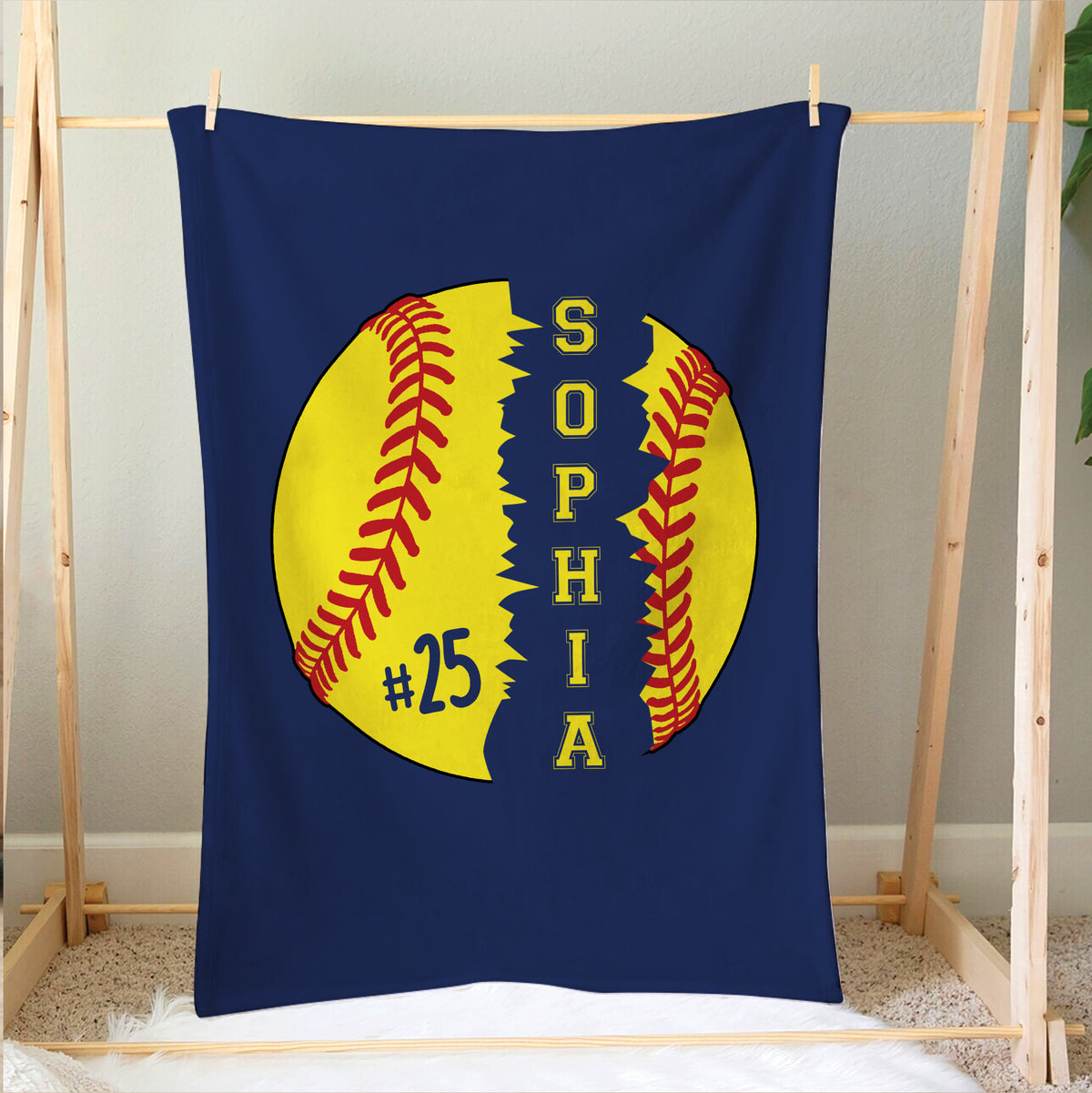 Softball blanket hanging on a wooden display frame with colorful softball artwork