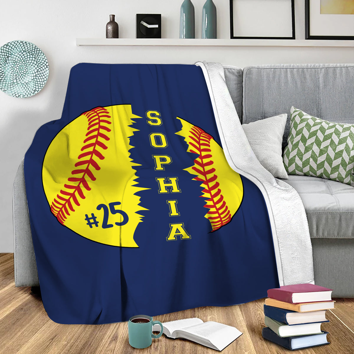 Softball throw blanket draped over a sofa with bold yellow, red, and navy sports artwork