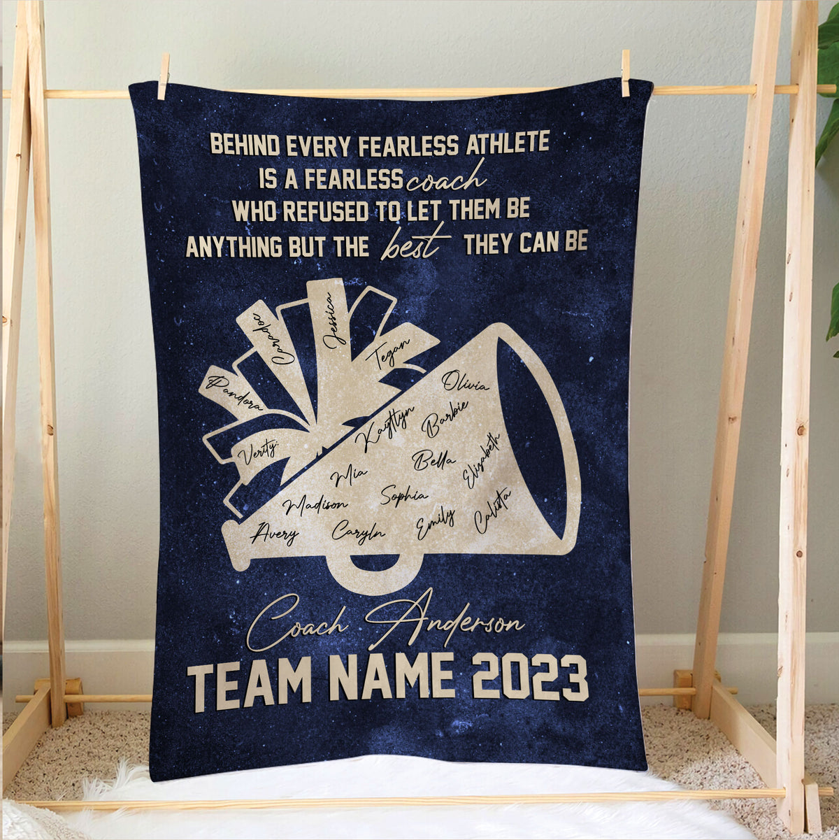 Cheerleading coach tribute blanket displayed on a bedroom frame with megaphone team artwork