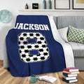Navy soccer throw blanket draped over a sofa in a modern living room
