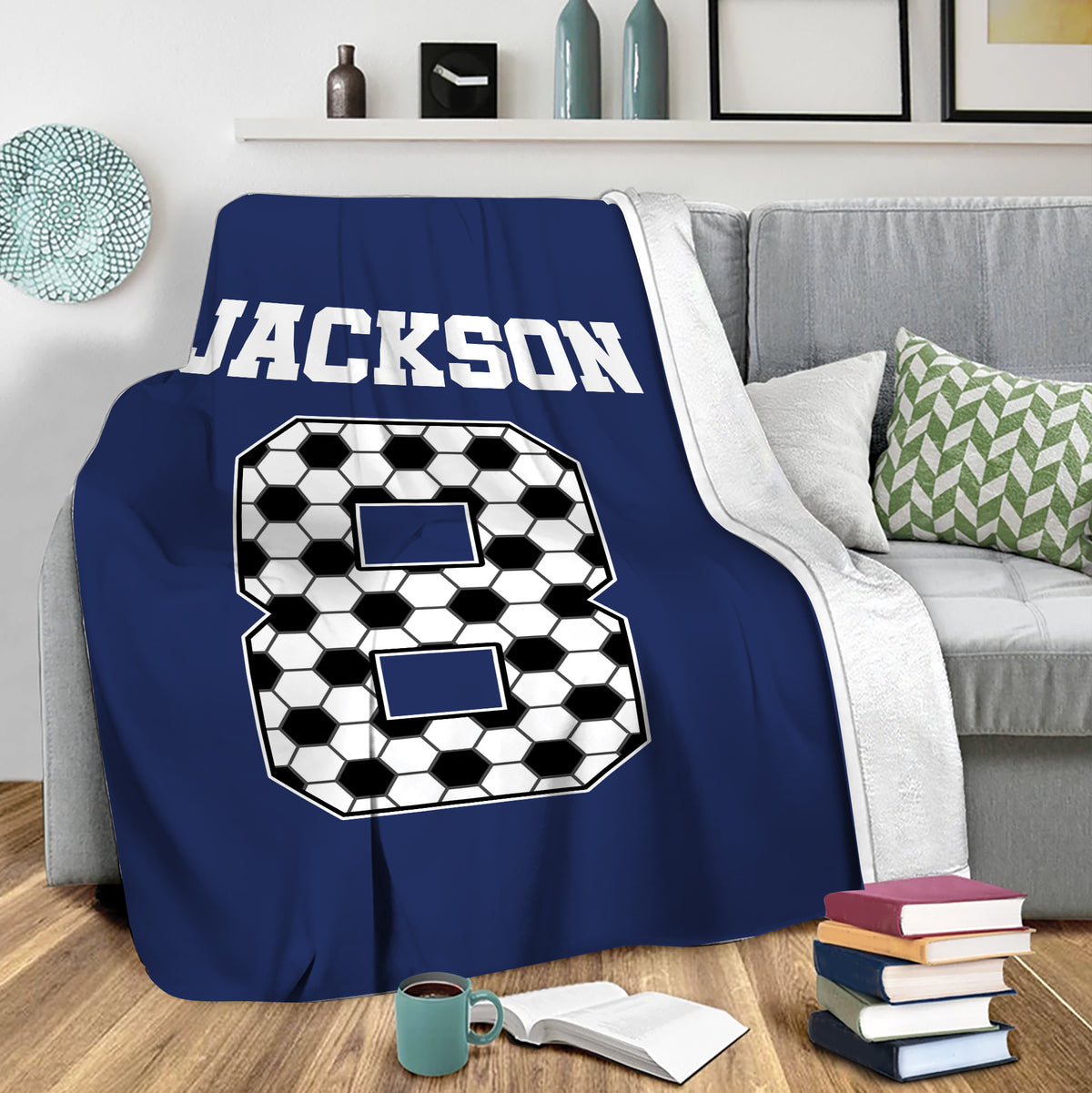 Navy soccer throw blanket draped over a sofa in a modern living room