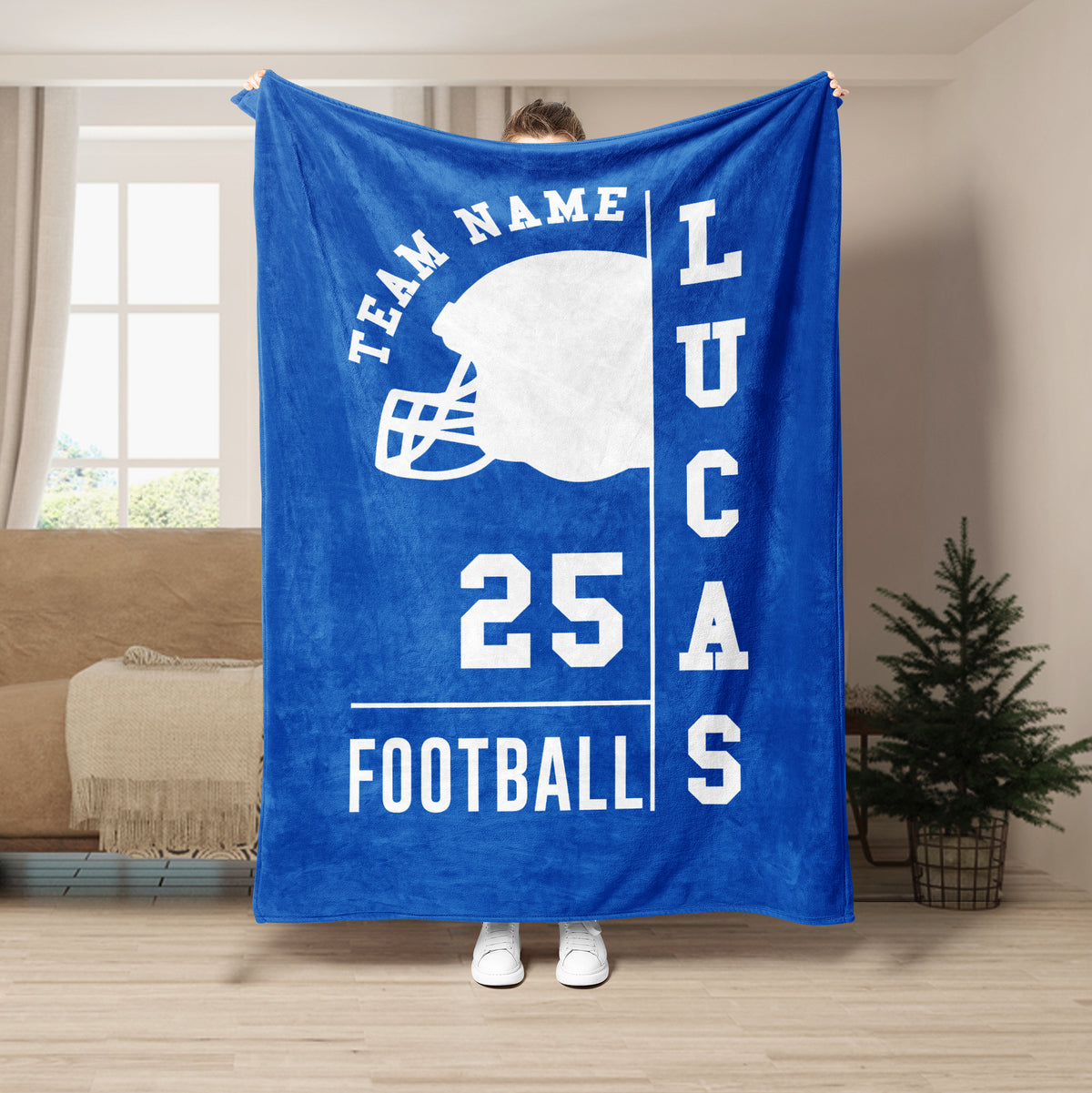 Blue football throw blanket shown in a living room with a white helmet graphic and athletic lettering