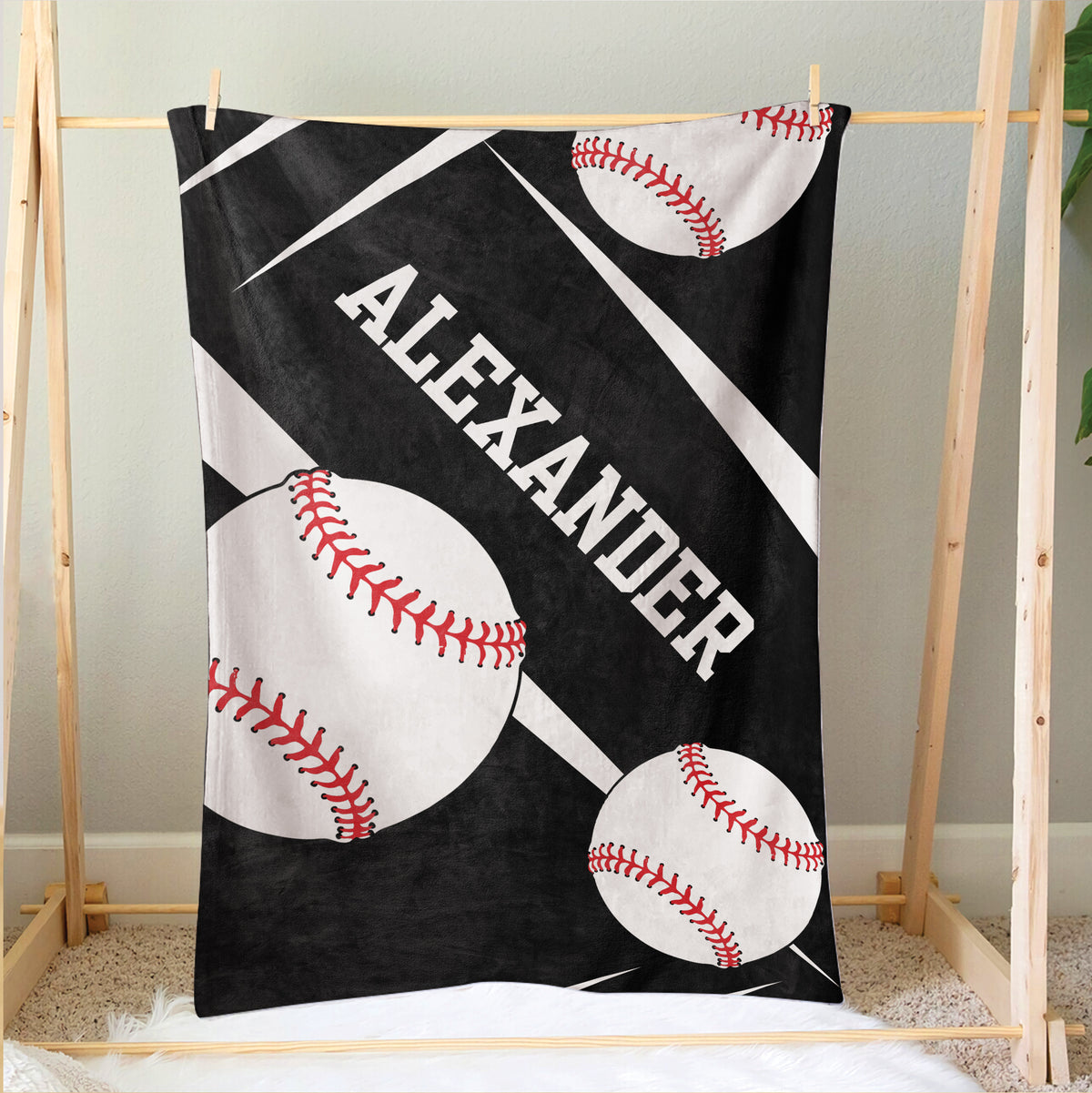 Black baseball throw blanket displayed on a wooden frame with oversized baseball artwork