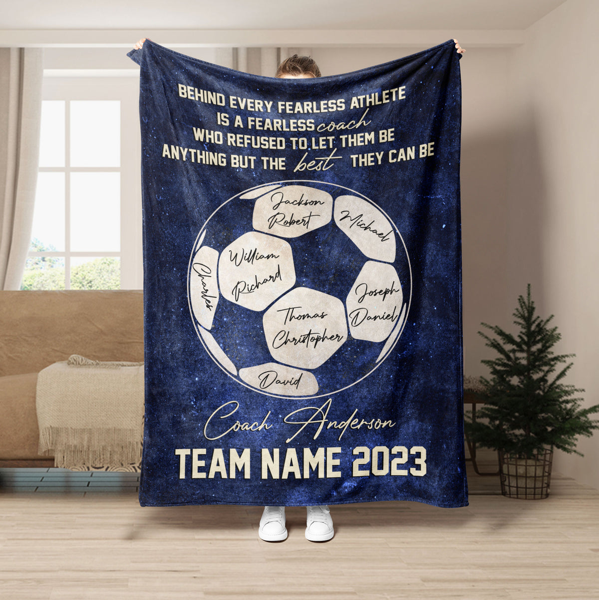 Navy soccer coach throw blanket displayed in a living room with soccer ball artwork