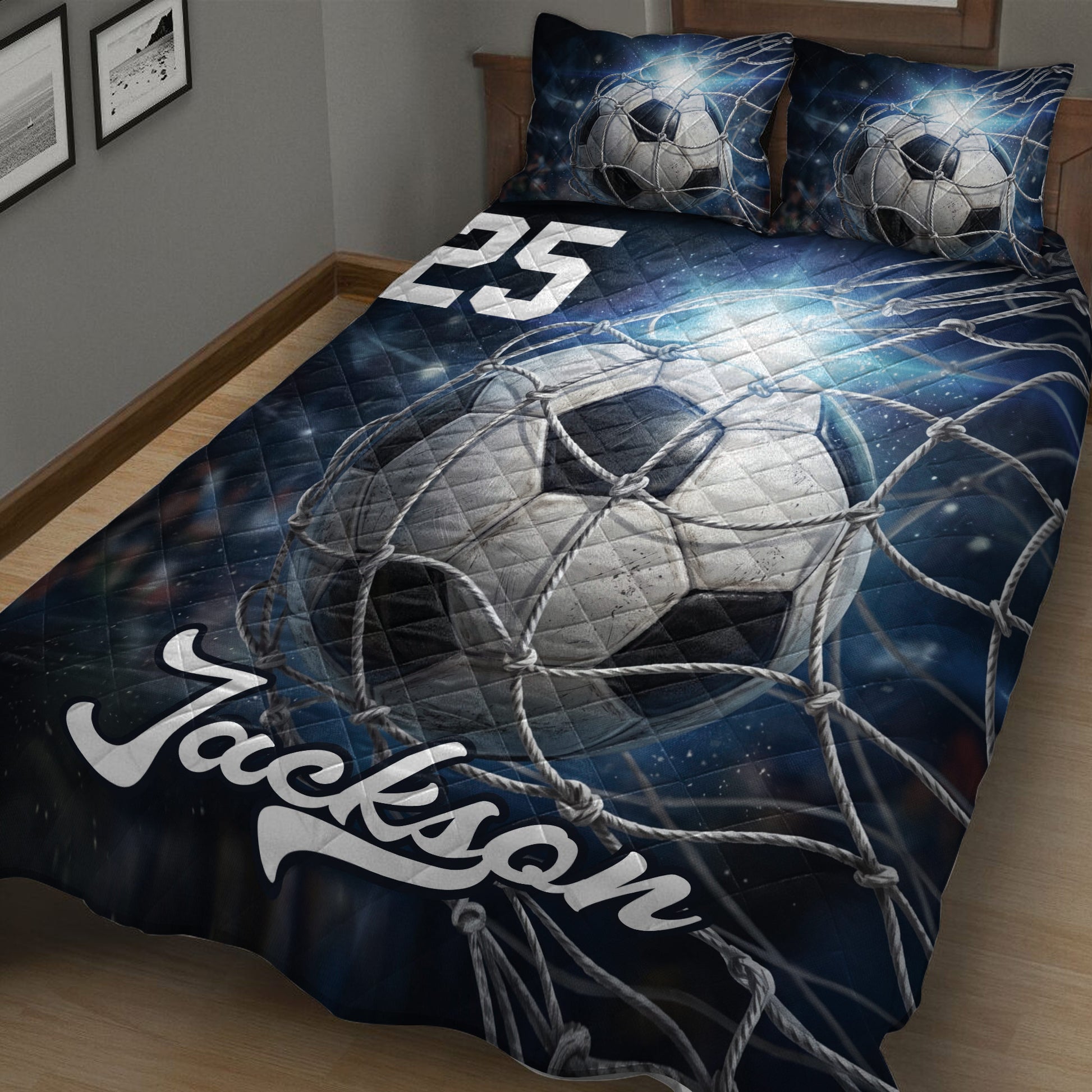 Close bedroom view of a dark blue soccer quilt blanket featuring a large ball caught in a net