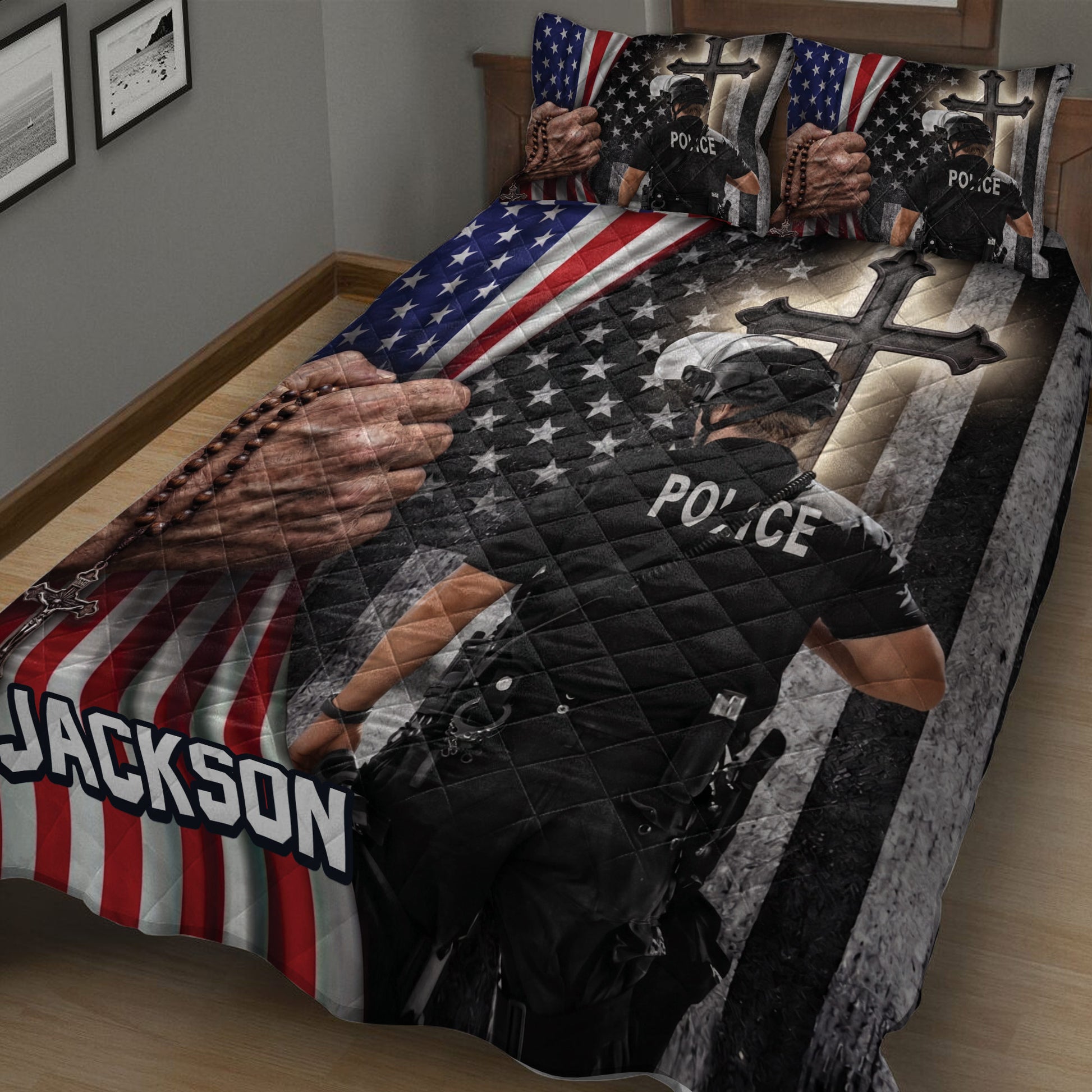 Close bedroom view of a police quilt blanket featuring an officer, American flag pattern, stars, and dark cross design