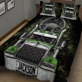 Close angled view of black and green semi-truck quilt artwork on a bedroom bed