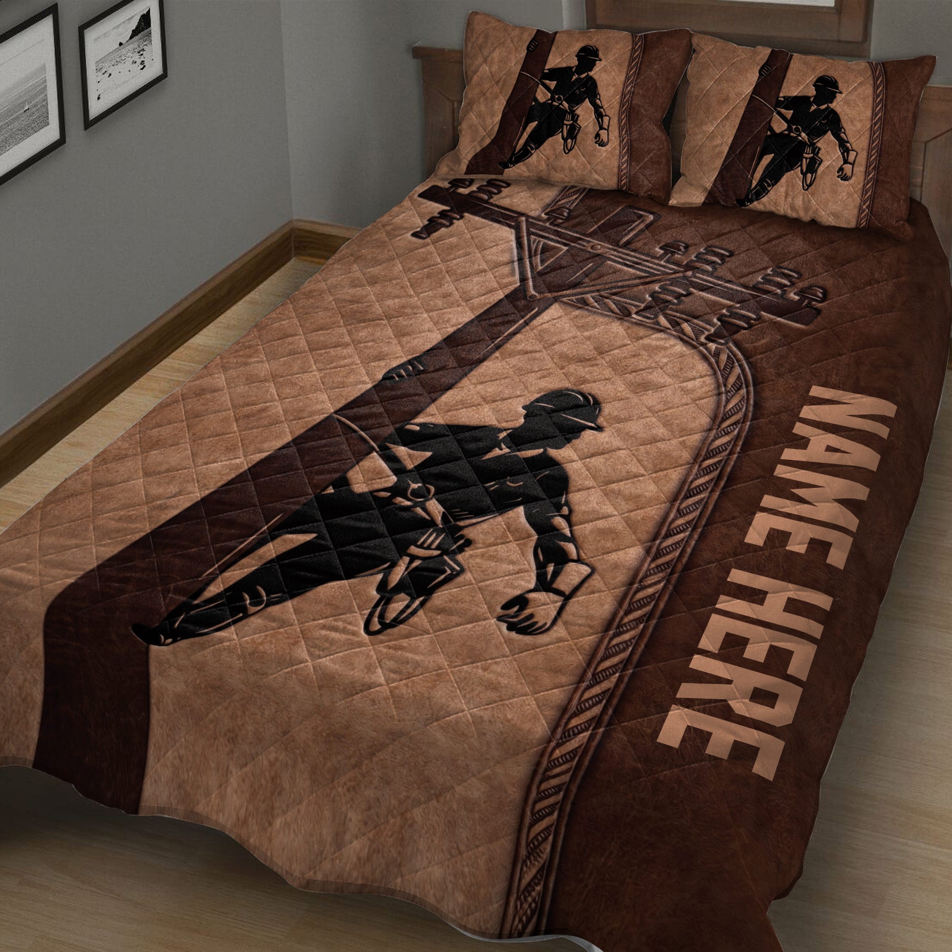 Close view of brown lineman quilt blanket featuring a power lineworker and electrical equipment