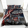 Patriotic trucker quilt blanket displayed on a bed with red semi-trucks and bold navy artwork