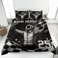 Racing quilt blanket displayed on a bed with helmeted driver artwork, checkered flags, stars, and monochrome styling
