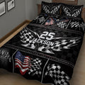 Close bedroom view of racing quilt blanket featuring crossed checkered flags, eagle artwork, and bold geometric patterns