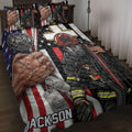 Firefighter quilt blanket displayed on a bed with patriotic stripes, fire gear, helmet, dog tags, and department emblem artwork