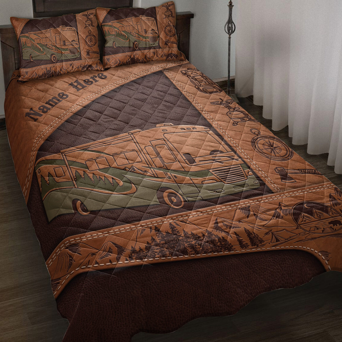Camping quilt blanket displayed on a bed with an RV, mountains, trees, compass, and outdoor gear artwork
