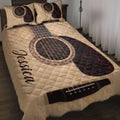 Acoustic guitar quilt blanket styled on a bed with matching guitar-themed pillow designs
