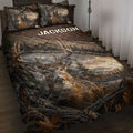 Deer quilt blanket displayed on a bed with realistic buck artwork, antlers, forest scenery, and rustic brown tones