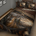 Close bedroom view of a deer quilt blanket featuring a realistic buck, antlers, trees, and rustic woodland artwork