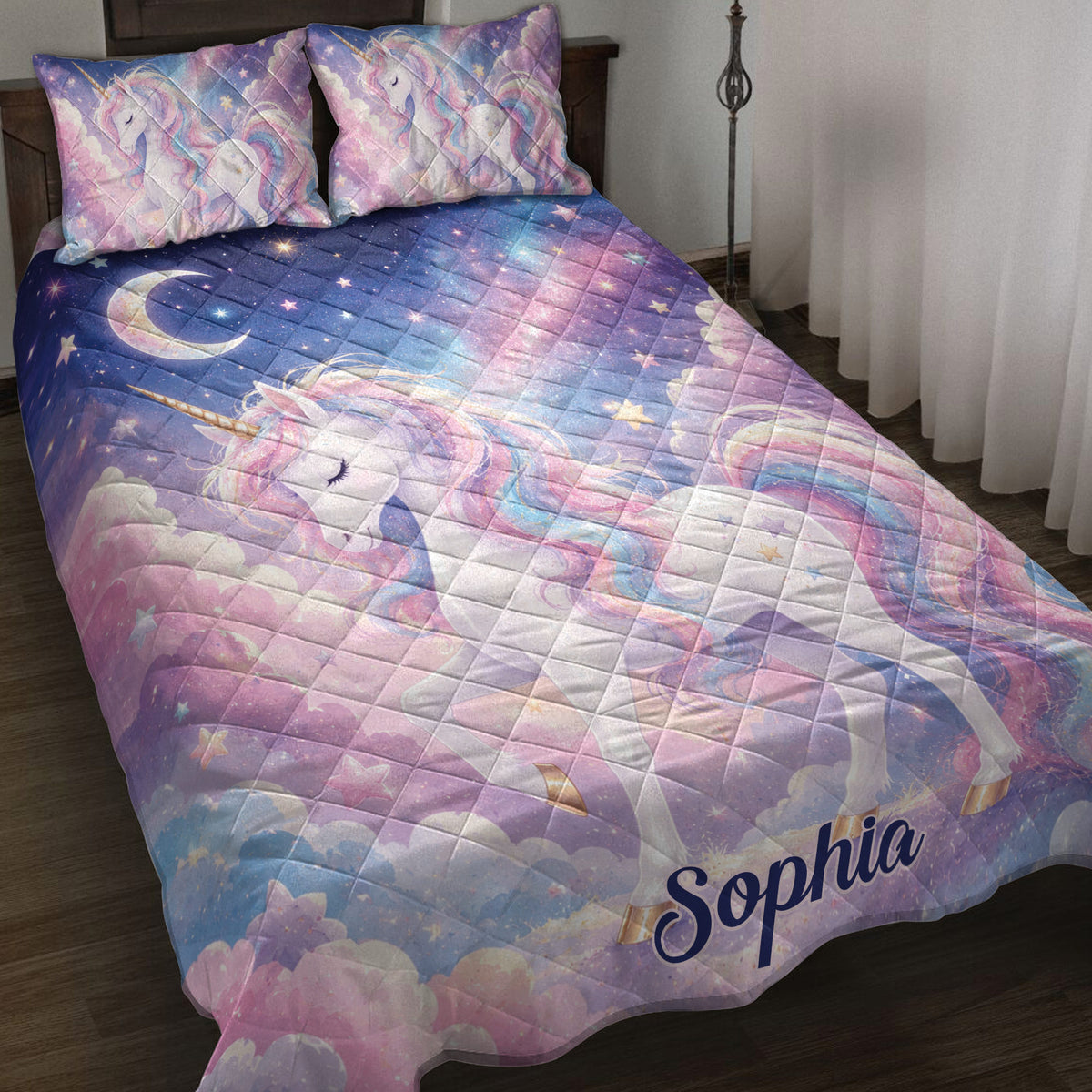 Pastel unicorn quilt blanket displayed on a bed with stars, clouds, moon, and rainbow-colored artwork