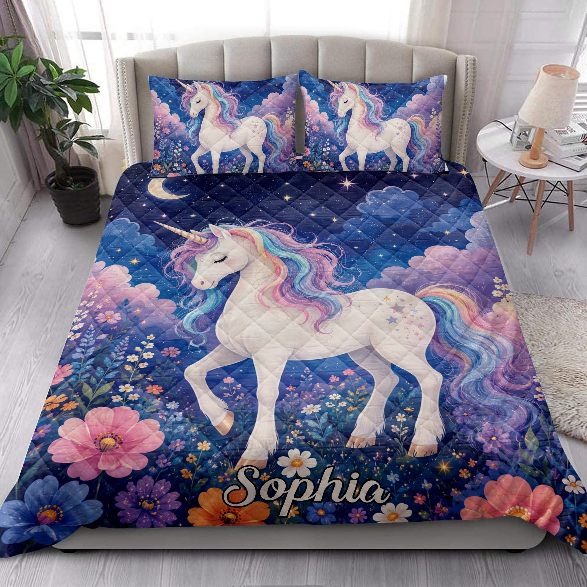 Unicorn quilt blanket styled in a bright bedroom with colorful unicorns, flowers, stars, and navy blue artwork