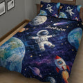 Close bedroom view of an astronaut quilt blanket featuring planets, rockets, stars, and deep blue space imagery