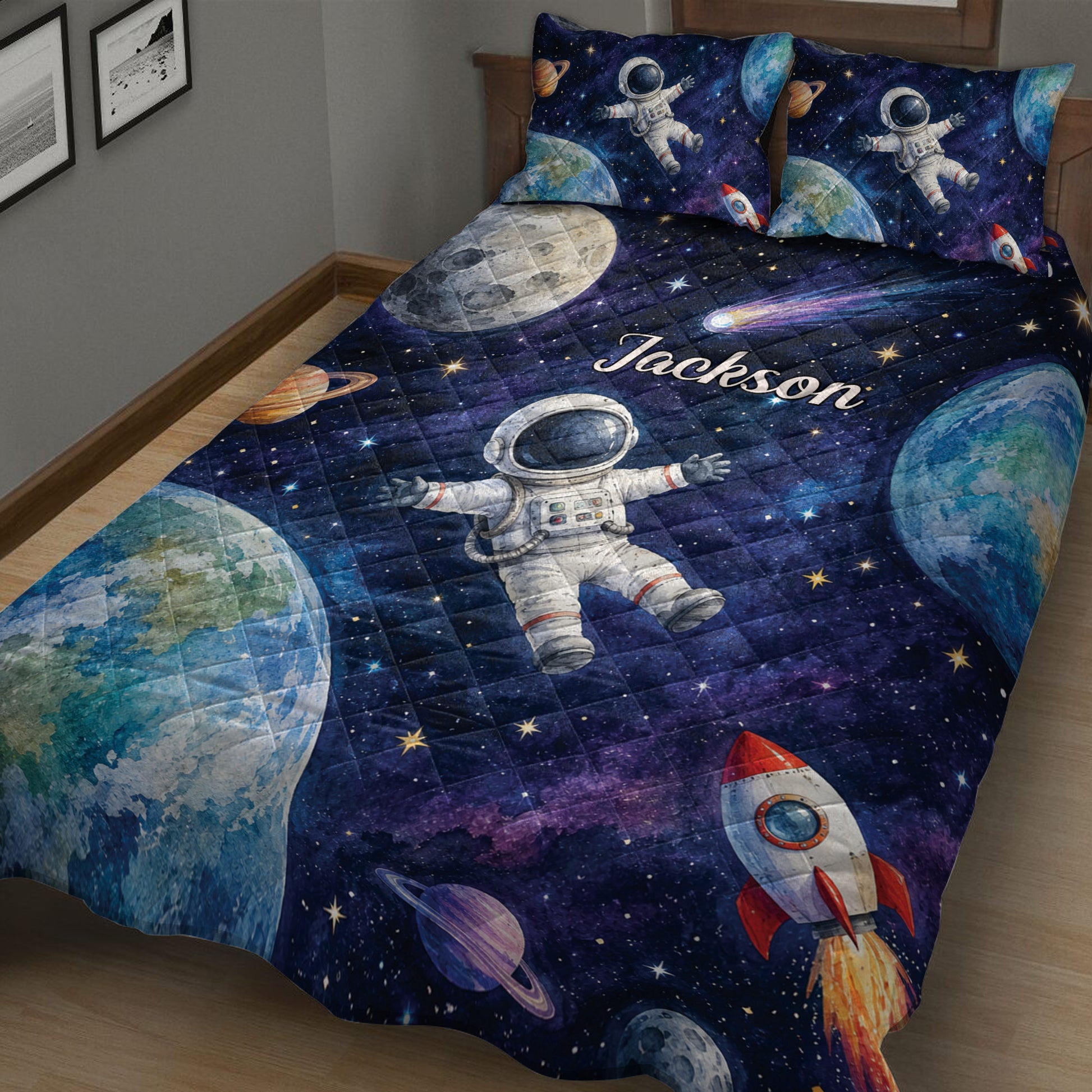 Close bedroom view of an astronaut quilt blanket featuring planets, rockets, stars, and deep blue space imagery