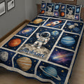 Close view of astronaut quilt blanket with planets, stars, rocket, satellite, and deep blue space design