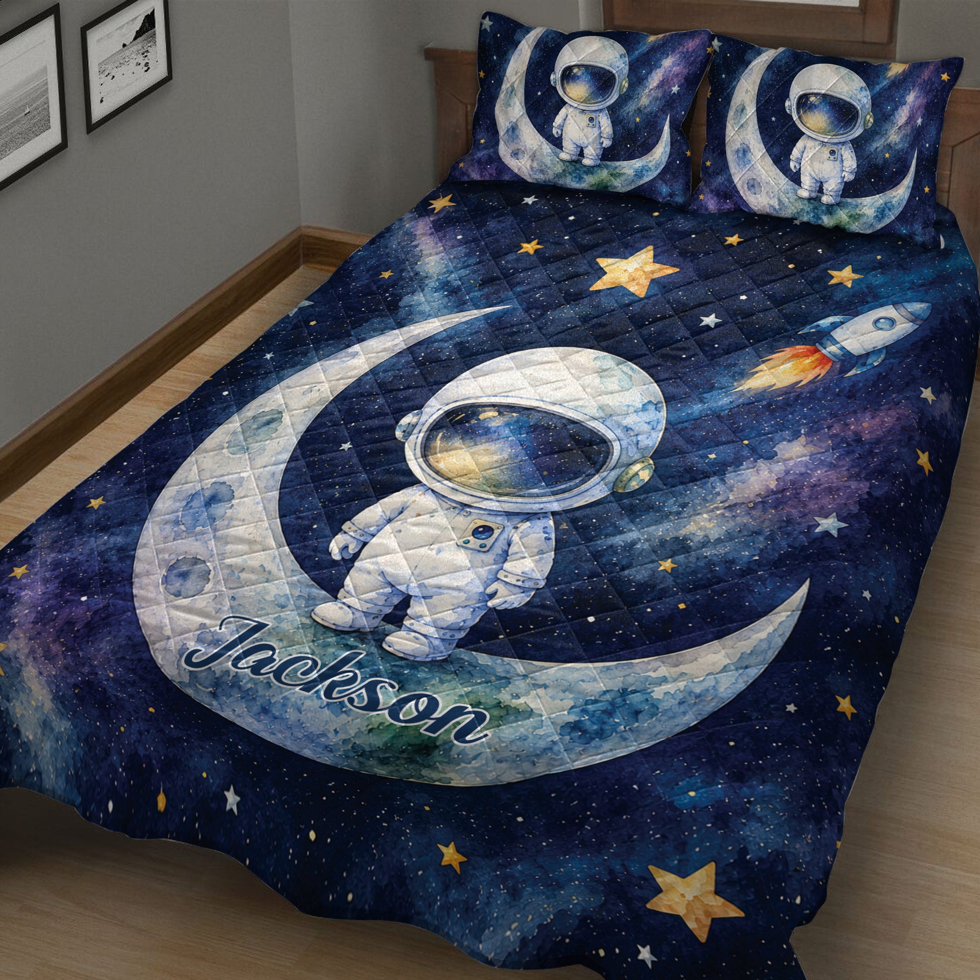 Close bedroom view of astronaut quilt blanket with rockets, stars, moons, and galaxy-inspired artwork