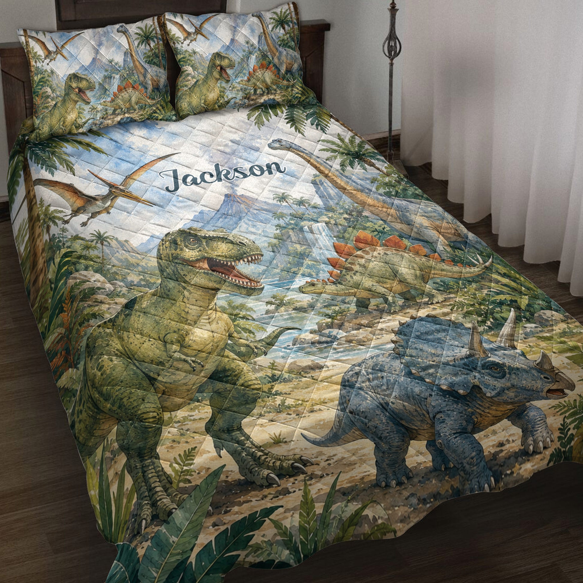 Dinosaur quilt blanket spread across a bed with jungle scenery, volcanoes, flying reptiles, and prehistoric animals