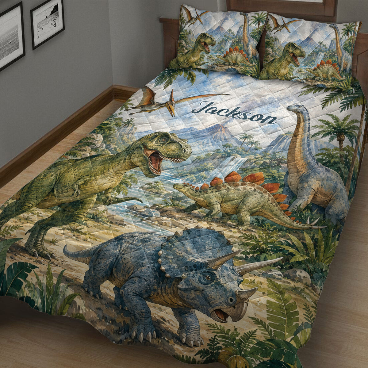 Close bedroom view of dinosaur quilt blanket featuring T-rex, long-neck dinosaur, stegosaurus, and triceratops artwork