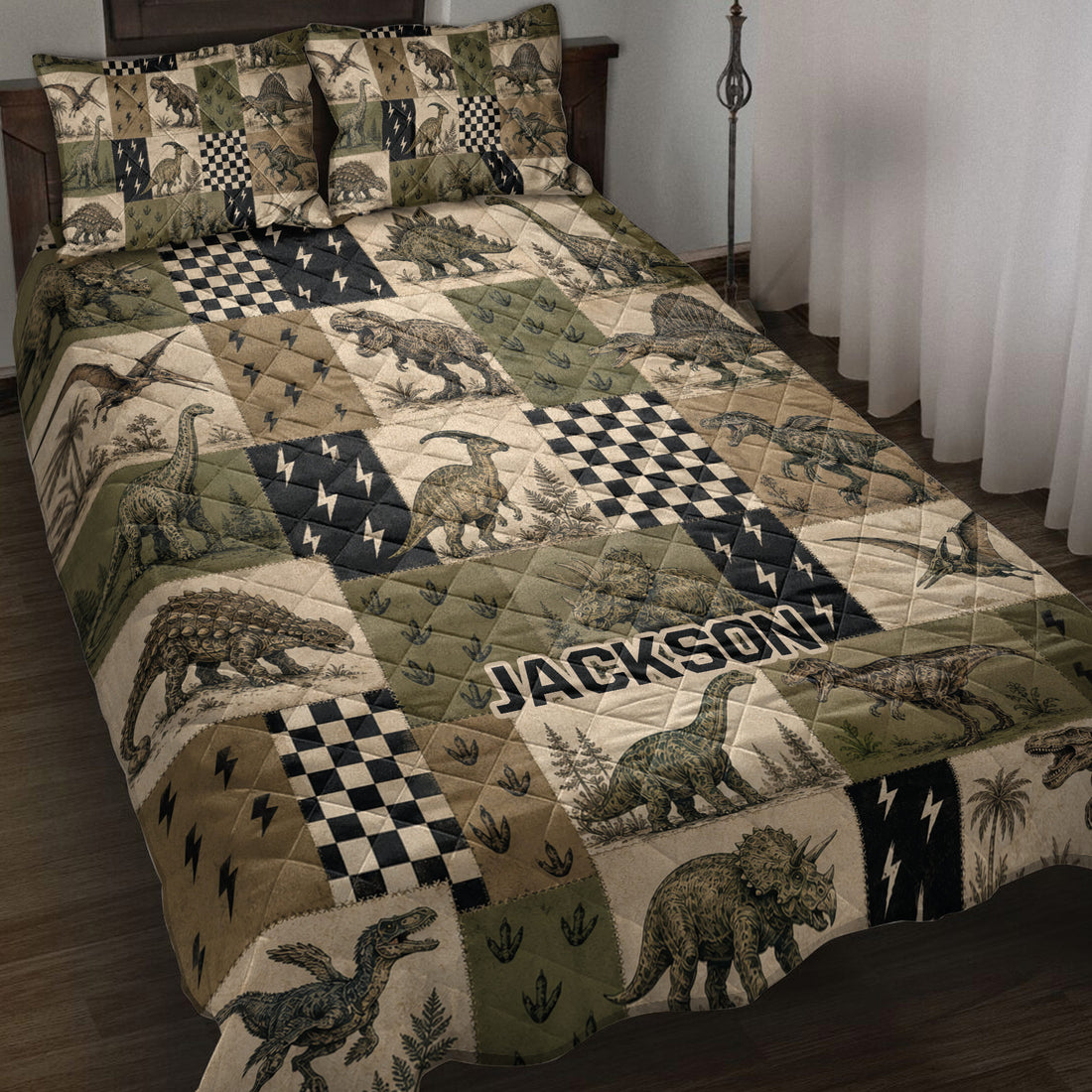 Dinosaur quilt blanket displayed on a bed with vintage patchwork artwork in olive green, tan, and black