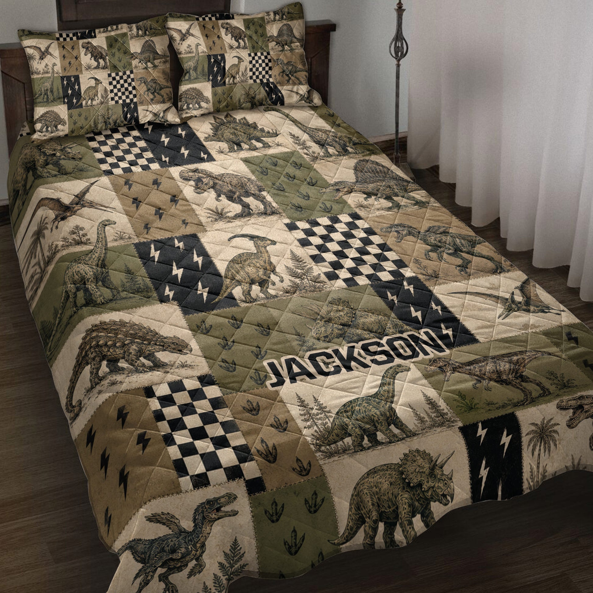 Dinosaur quilt blanket displayed on a bed with vintage patchwork artwork in olive green, tan, and black