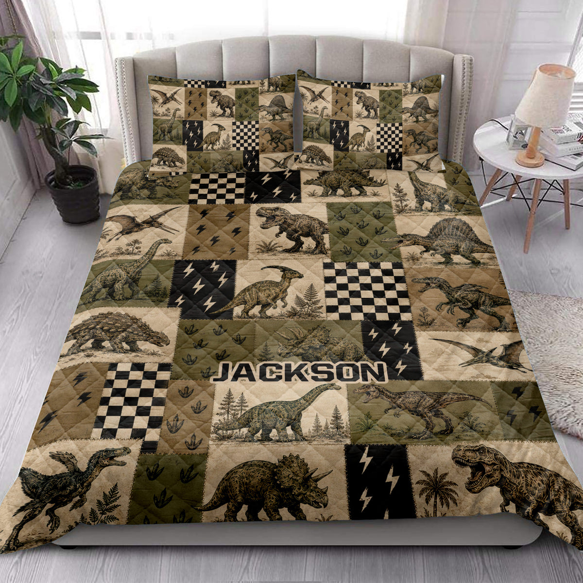 Dinosaur quilt blanket styled across a bedroom with matching dinosaur artwork and earthy patchwork colors
