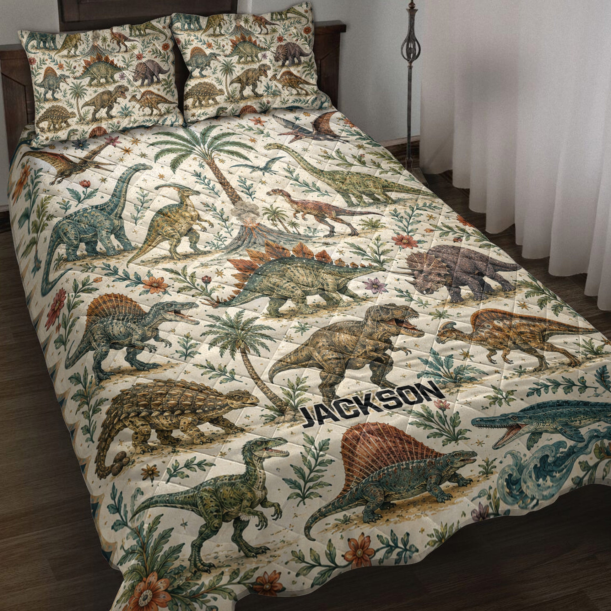 Dinosaur quilt blanket displayed on a bed with detailed prehistoric animals, tropical plants, flowers, and a volcano