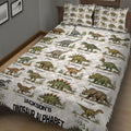Dinosaur quilt blanket and illustrated pillows shown in a cozy bedroom setting with alphabet artwork