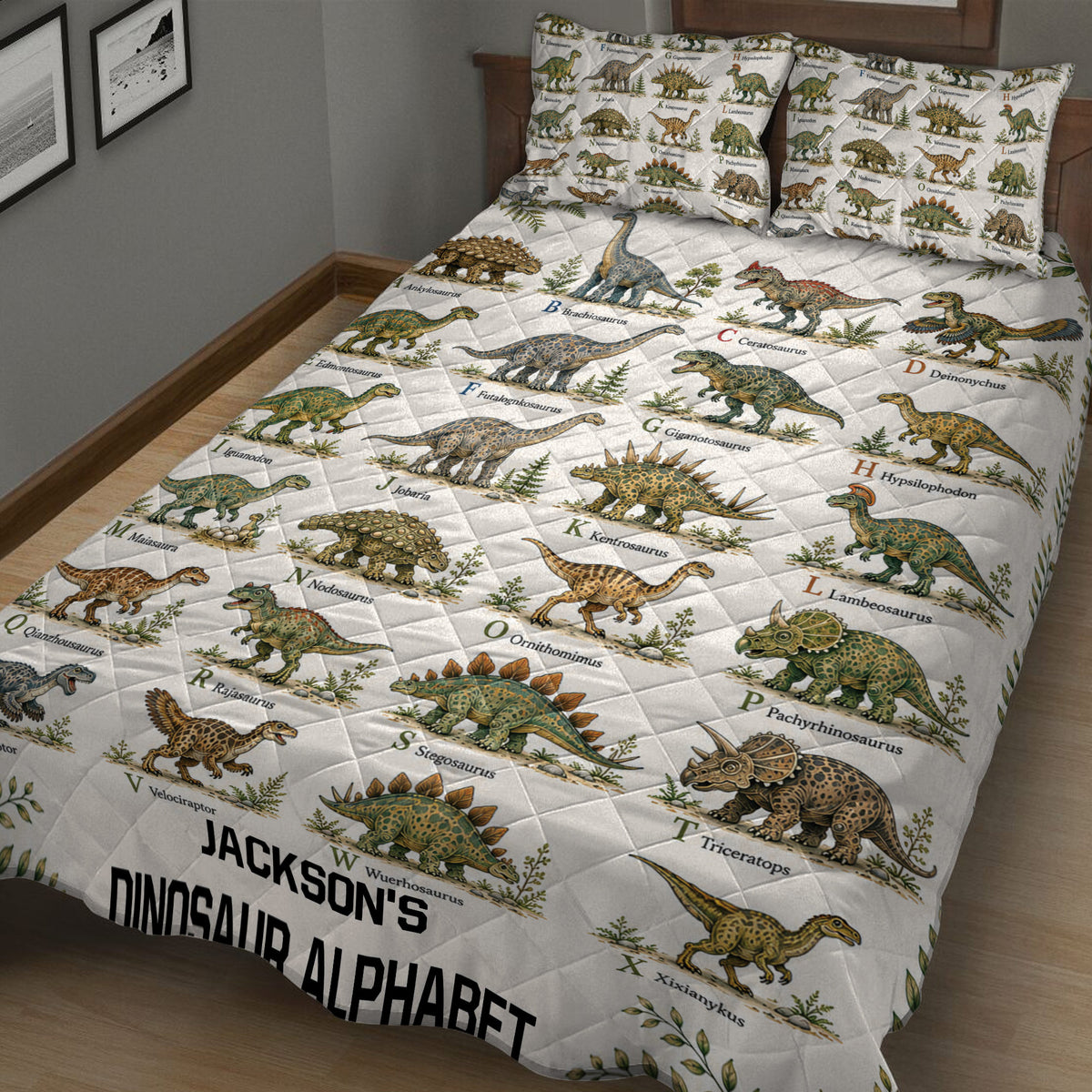 Dinosaur quilt blanket and illustrated pillows shown in a cozy bedroom setting with alphabet artwork