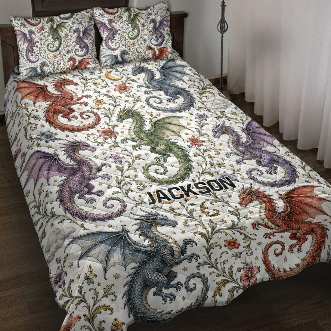 Dragon quilt blanket spread across a bed with colorful winged dragons, flowers, stars, and moon artwork