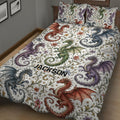 Close bedroom view of a colorful dragon quilt blanket with red, blue, green, and purple dragons