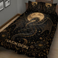 Angled bedroom view of a black dragon quilt blanket with moonlit wings, stars, and ornate floral borders